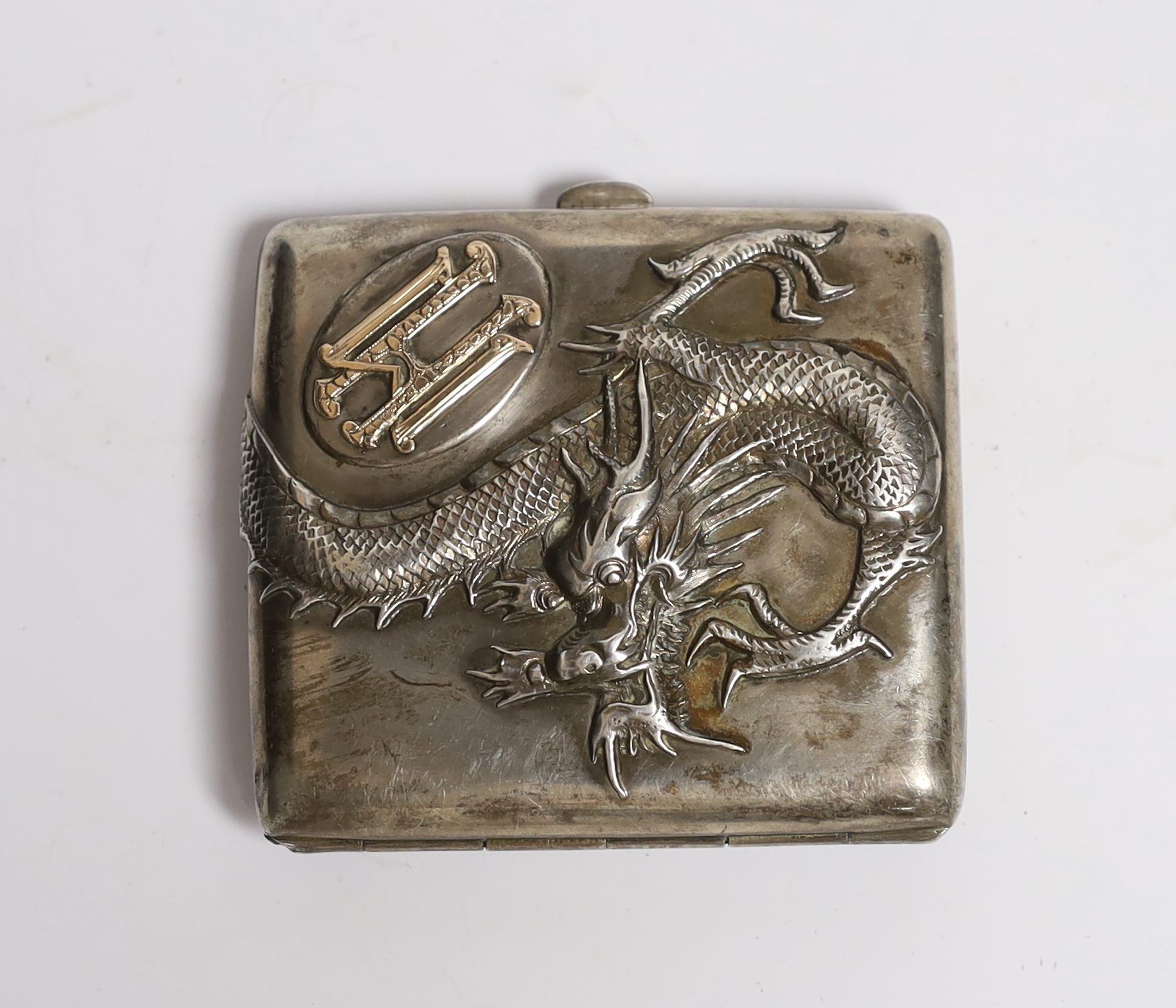 A late 19th/early 20th century Chinese Export white metal cigarette case, by Tuck Chang?, with yellow metal monogram applique and embossed with a dragon, 78mm.